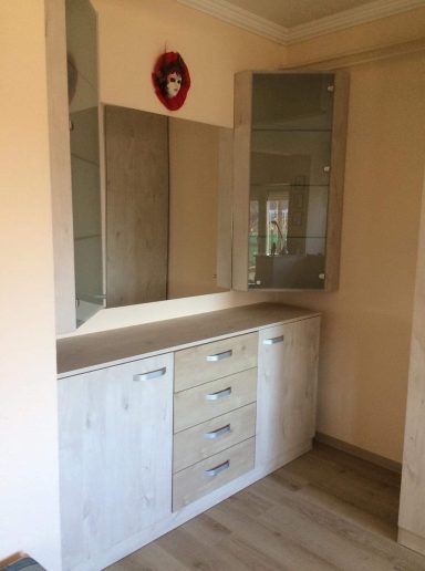 Moderne kasten met een spiegel in een lichte kamer.