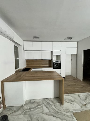 Moderne keuken met witmeubilair en een houten werkblad.