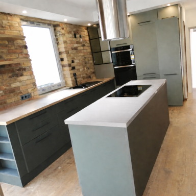Moderne keuken met groene kasten, een kookeiland en stenen muren.