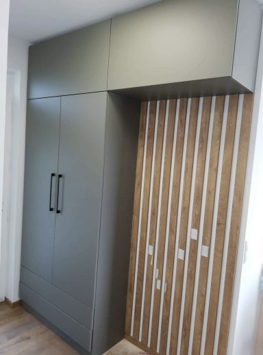 Moderne kast met een groene afwerking en houten panelen met verticale lijnen.